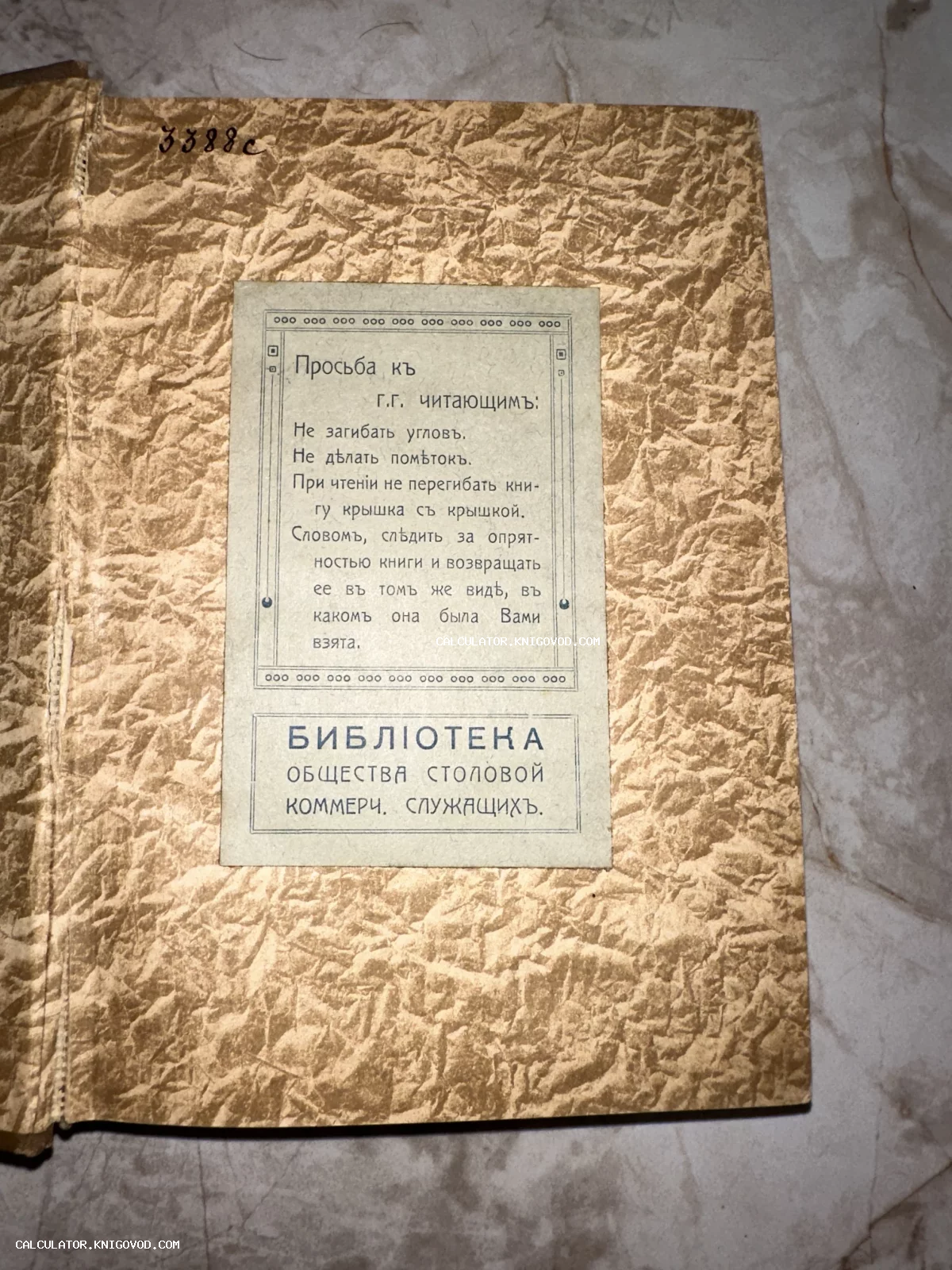 Внутренняя сторона старинного переплета с наклеенным листком правил пользования книгой из Библиотеки общества столовой коммерческих служащих.
