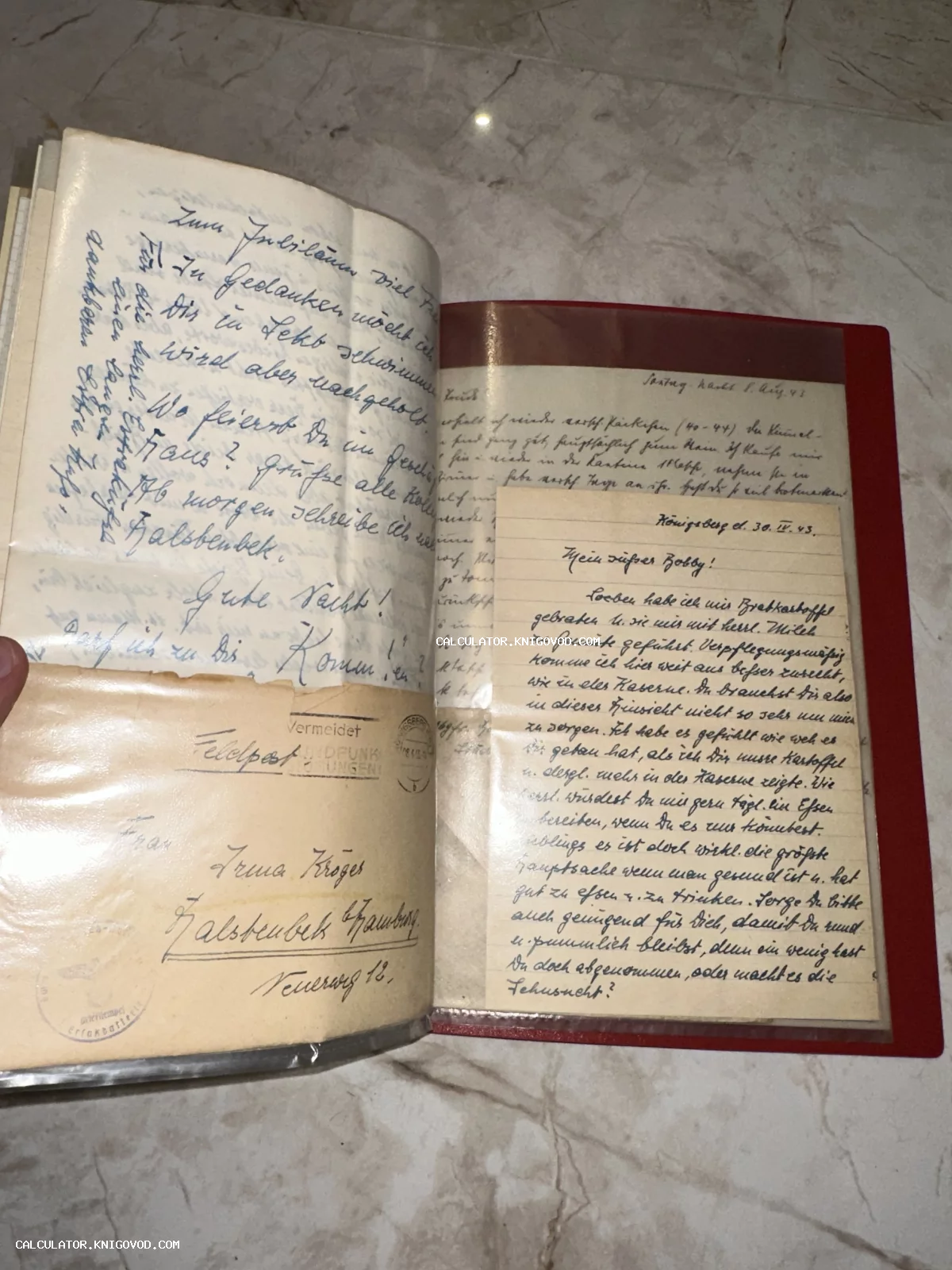 Раскрытый альбом с вложенными рукописными письмами на немецком языке и конвертом полевой почты периода Второй мировой войны.