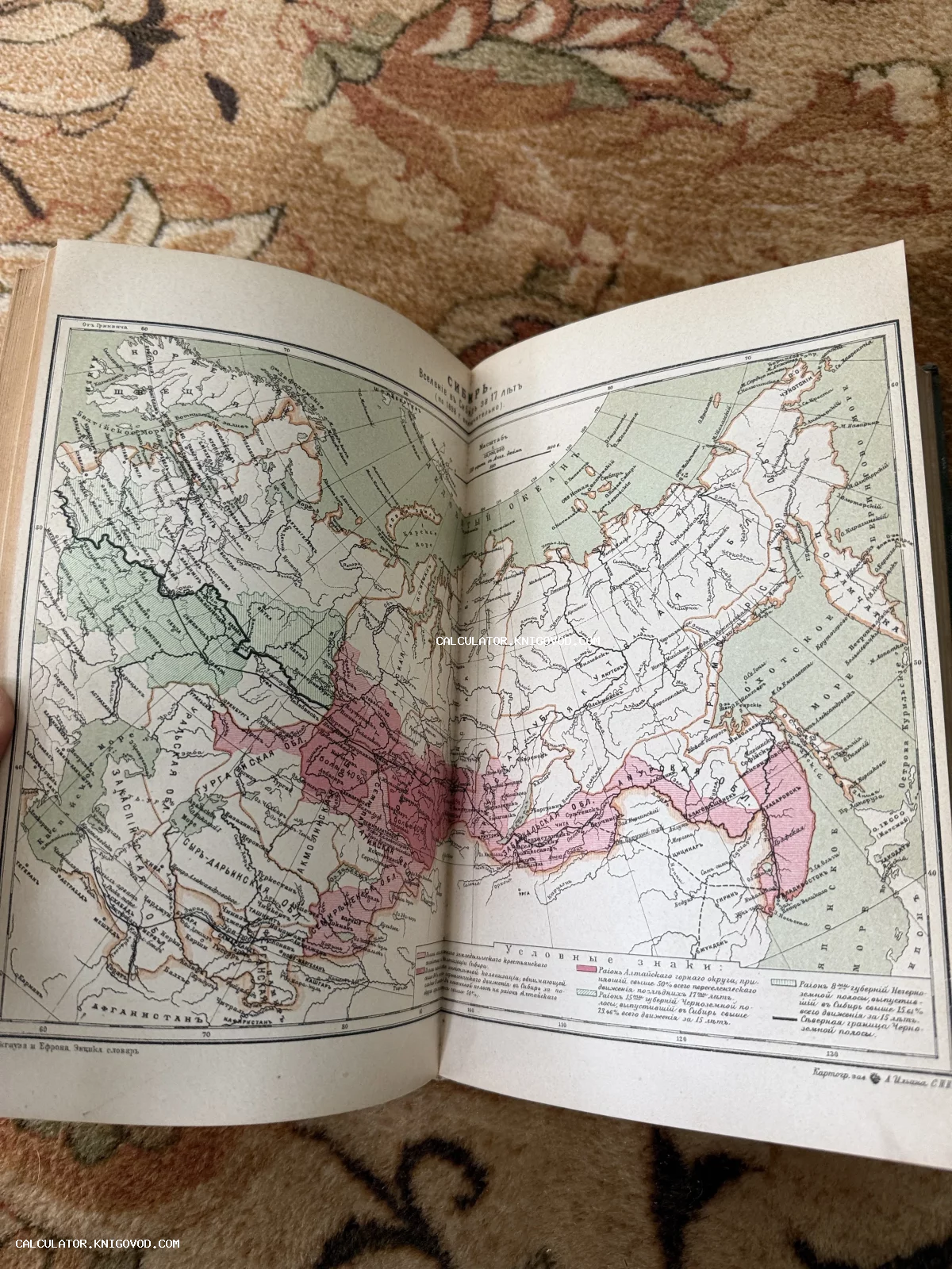 Разворот старинной книги с цветной литографированной картой Сибири и Дальнего Востока начала XX века.