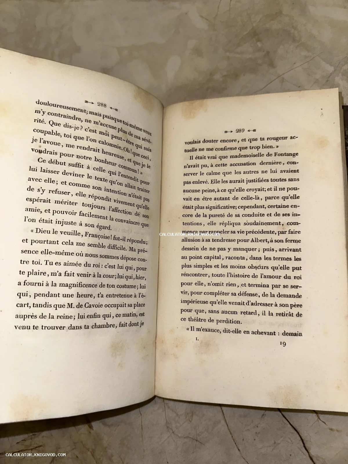 Открытая старинная книга на французском языке с пожелтевшими страницами и следами времени.