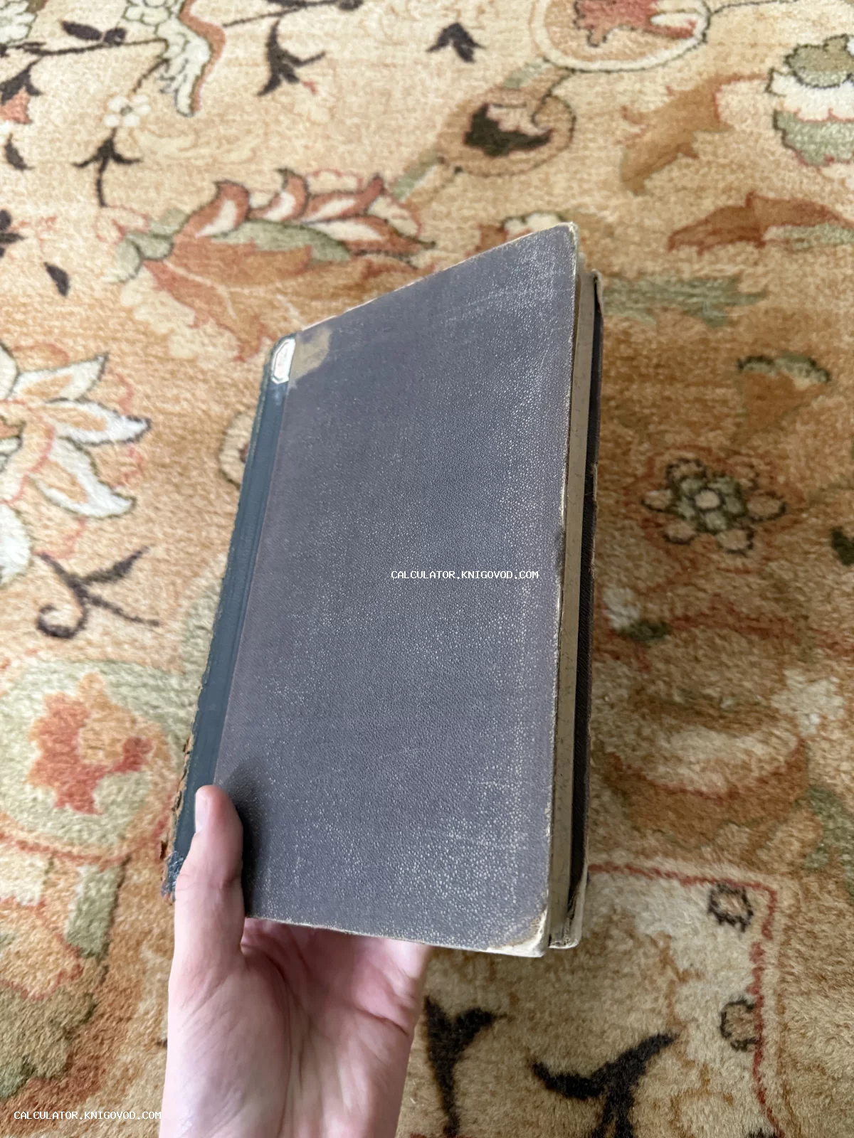 Старинная книга в темно-фиолетовом твердом переплете с заметными следами времени и потертыми краями.