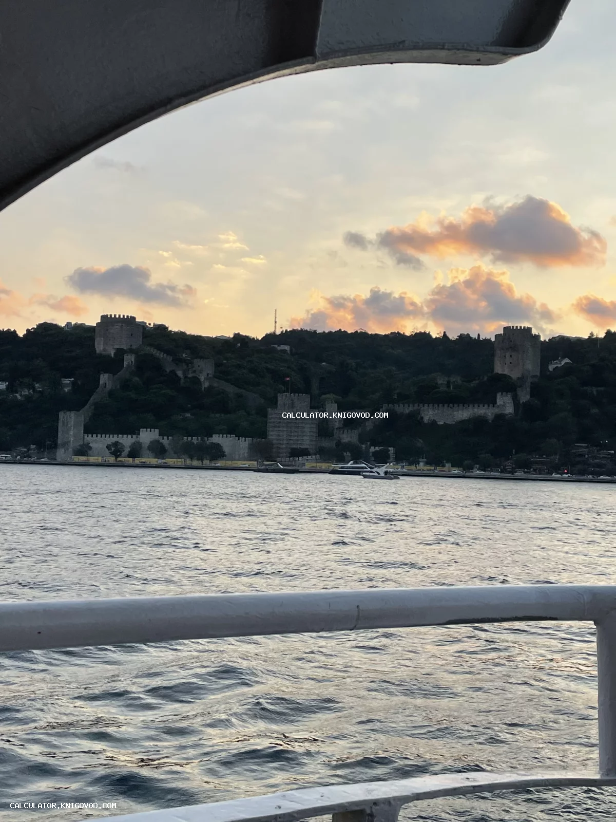 Вид на средневековую турецкую крепость Румелихисар с воды на фоне закатного неба.