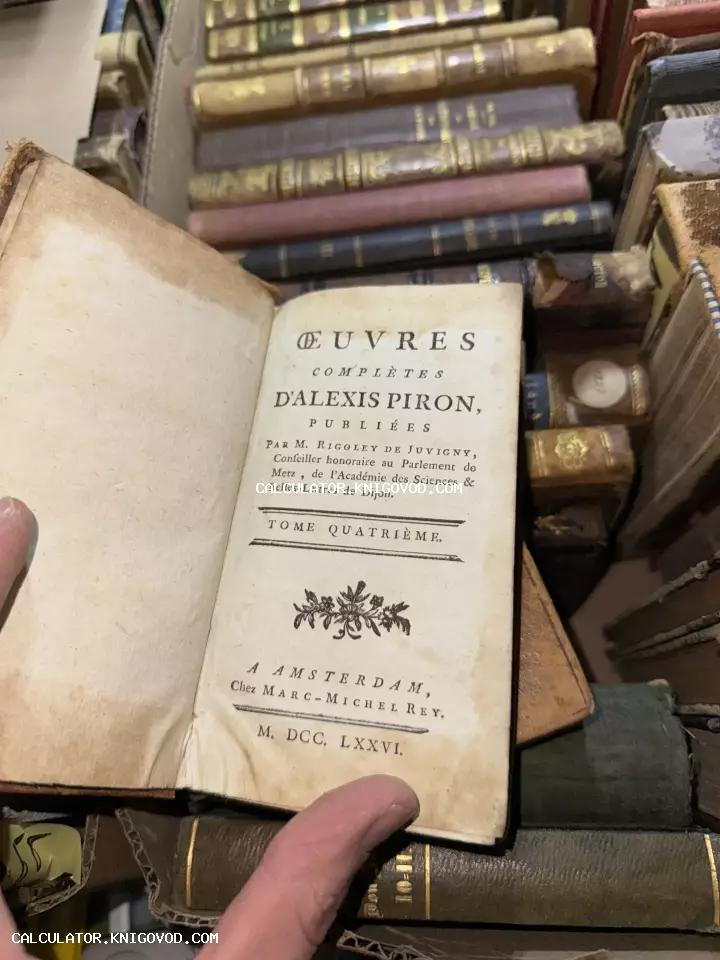 Разворот антикварной книги 'Oeuvres Completes d'Alexis Piron' 1776 года издания на фоне множества старинных томов в кожаных переплетах.