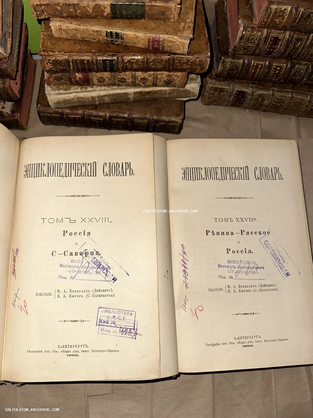 Раскрытые титульные листы двух томов антикварного энциклопедического словаря Брокгауза и Ефрона на фоне стопки старинных книг в кожаных переплетах.