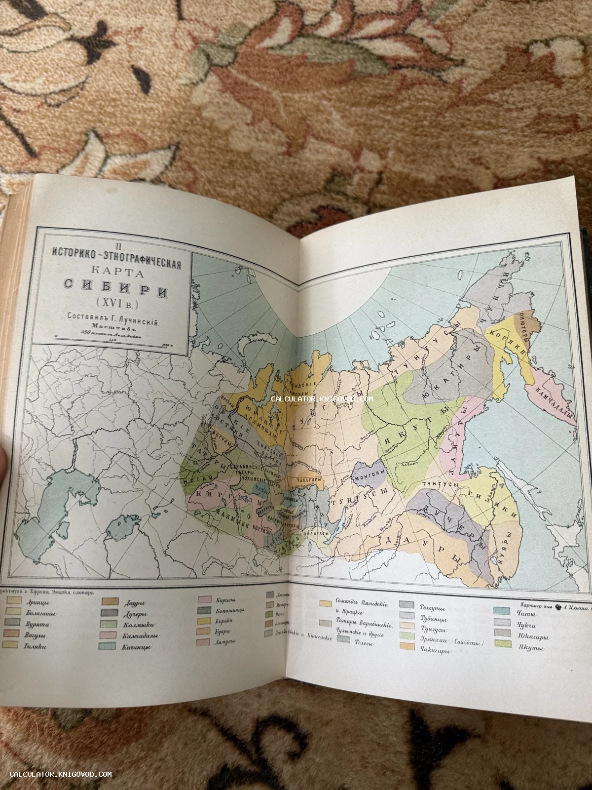 Разворот старинной книги с цветной историко-этнографической картой Сибири и Дальнего Востока XVI века с легендой племен и народов.