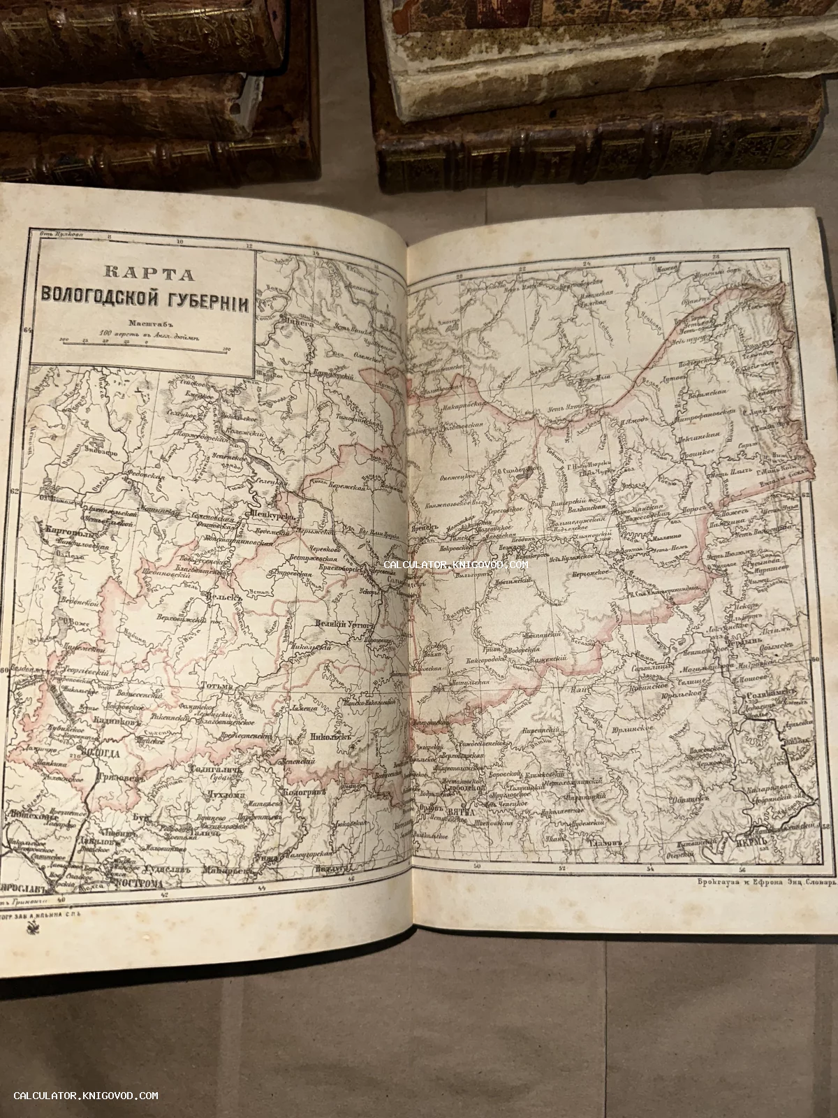 Раскрытая антикварная книга с детализированной картой Вологодской губернии из словаря Брокгауза и Ефрона.