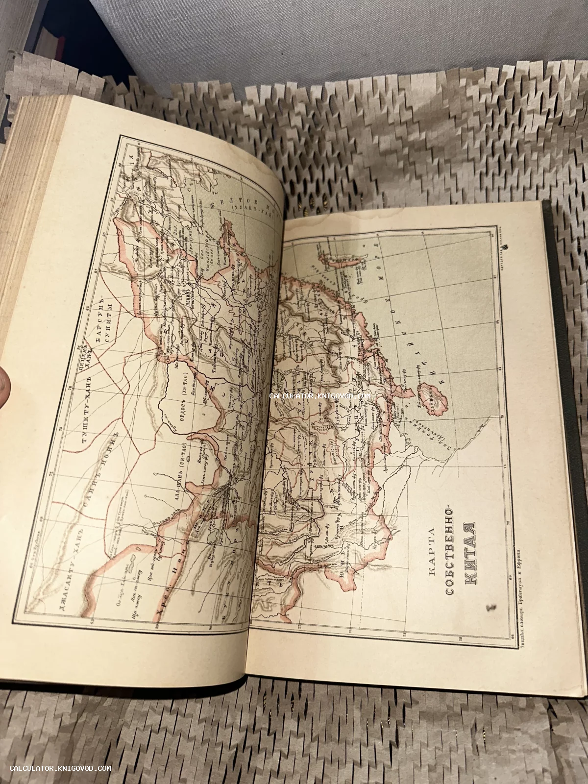 Разворот антикварной книги со старинной подробной картой Китая на русском языке.