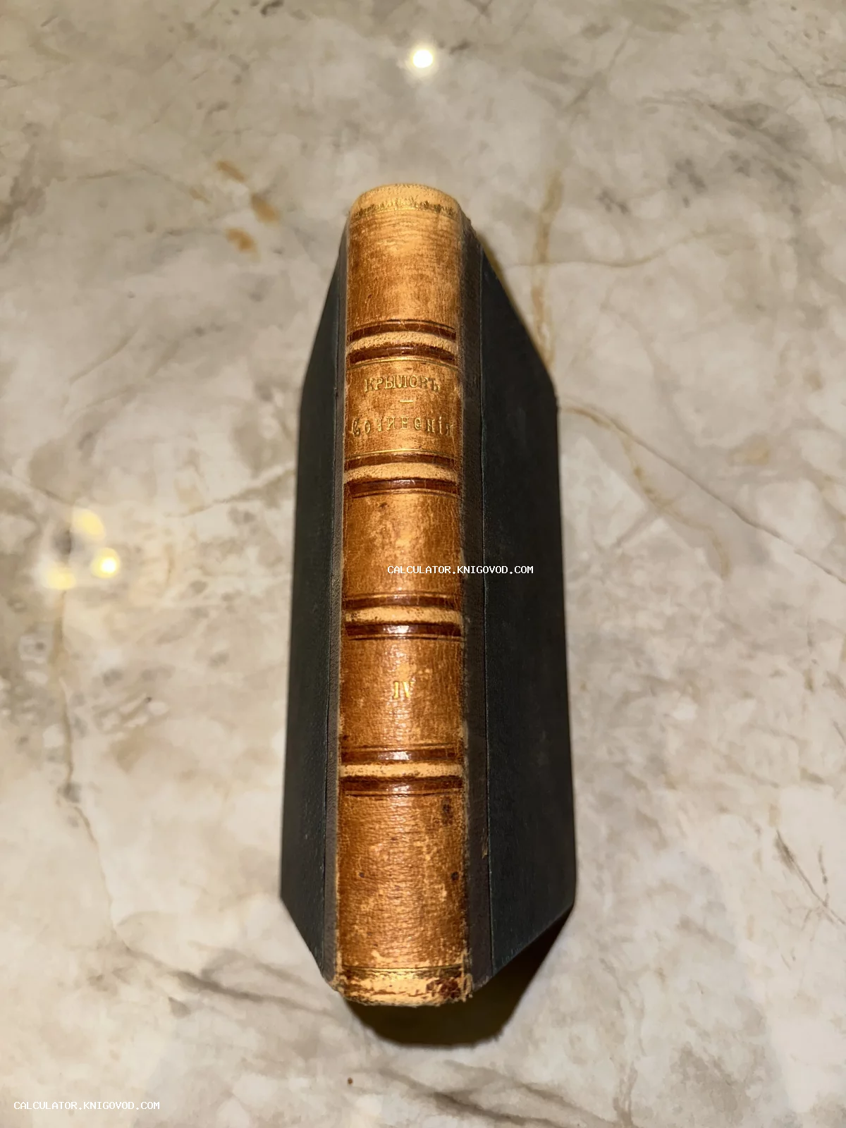 Кожаный корешок антикварной книги И. А. Крылова «Сочинения», том 4, с золотым тиснением на мраморном фоне.