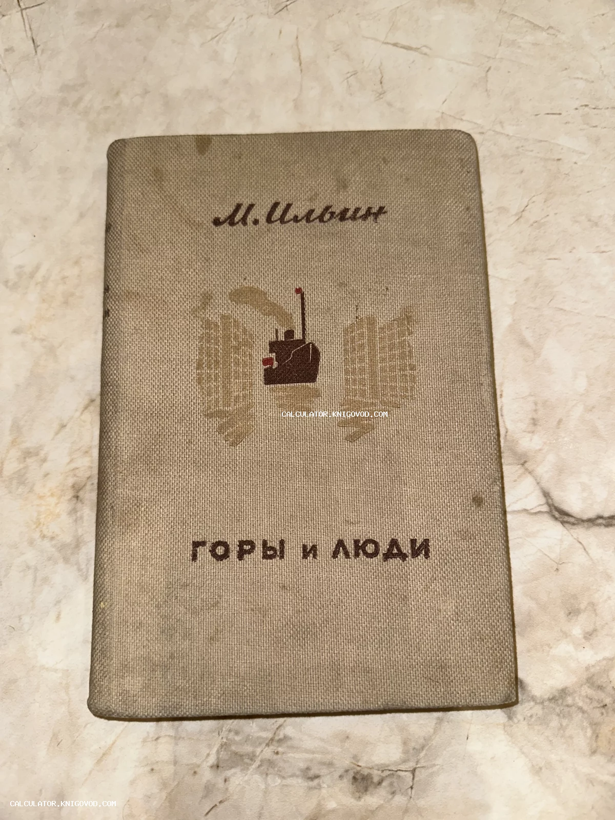 Обложка старой книги М. Ильина «Горы и люди» в сером тканевом переплете с минималистичным рисунком парохода.
