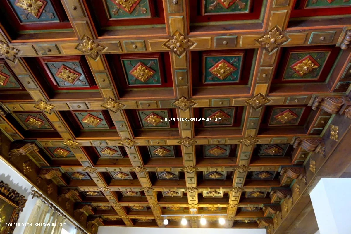 Деревянный кессонный потолок с декоративной резьбой, позолоченными розетками и цветными вставками в классическом стиле.