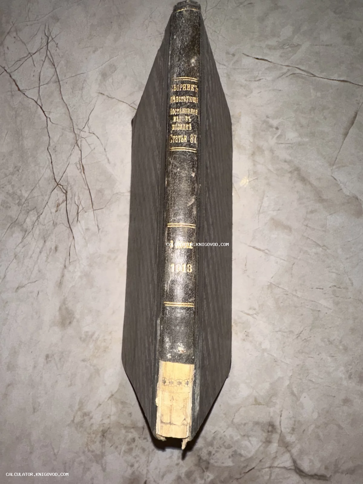 Вид на корешок антикварной книги 1913 года с золотым тиснением на темном переплете.