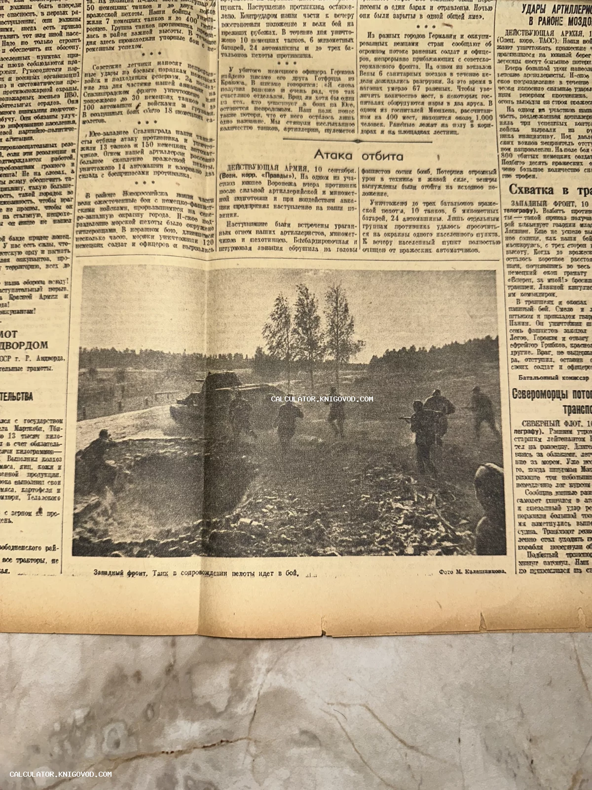 Черно-белая фотография из советской газеты периода Второй мировой войны, на которой изображен танк в сопровождении пехоты на поле боя.