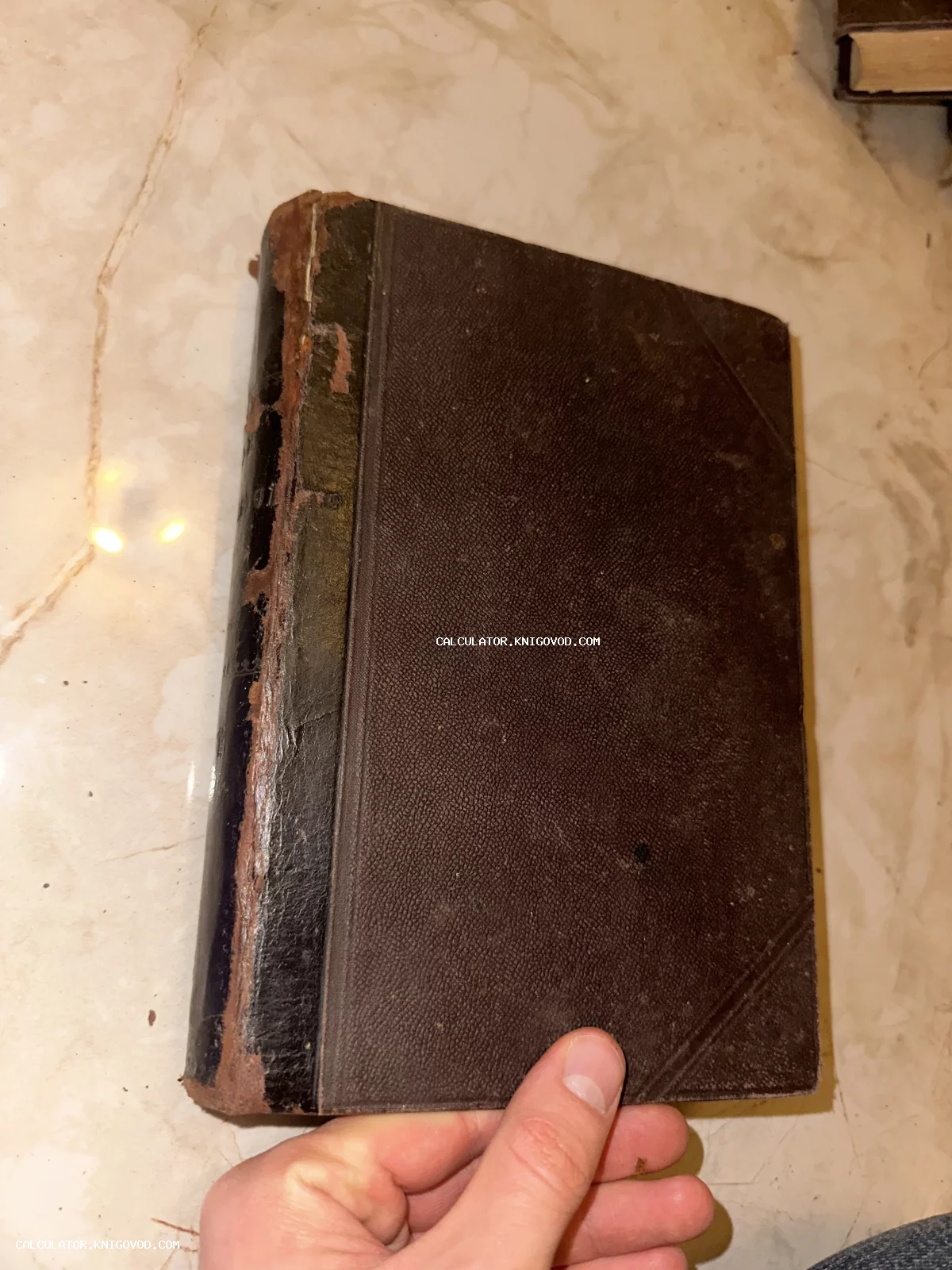 Старинная книга с темной фактурной обложкой и потертым кожаным корешком