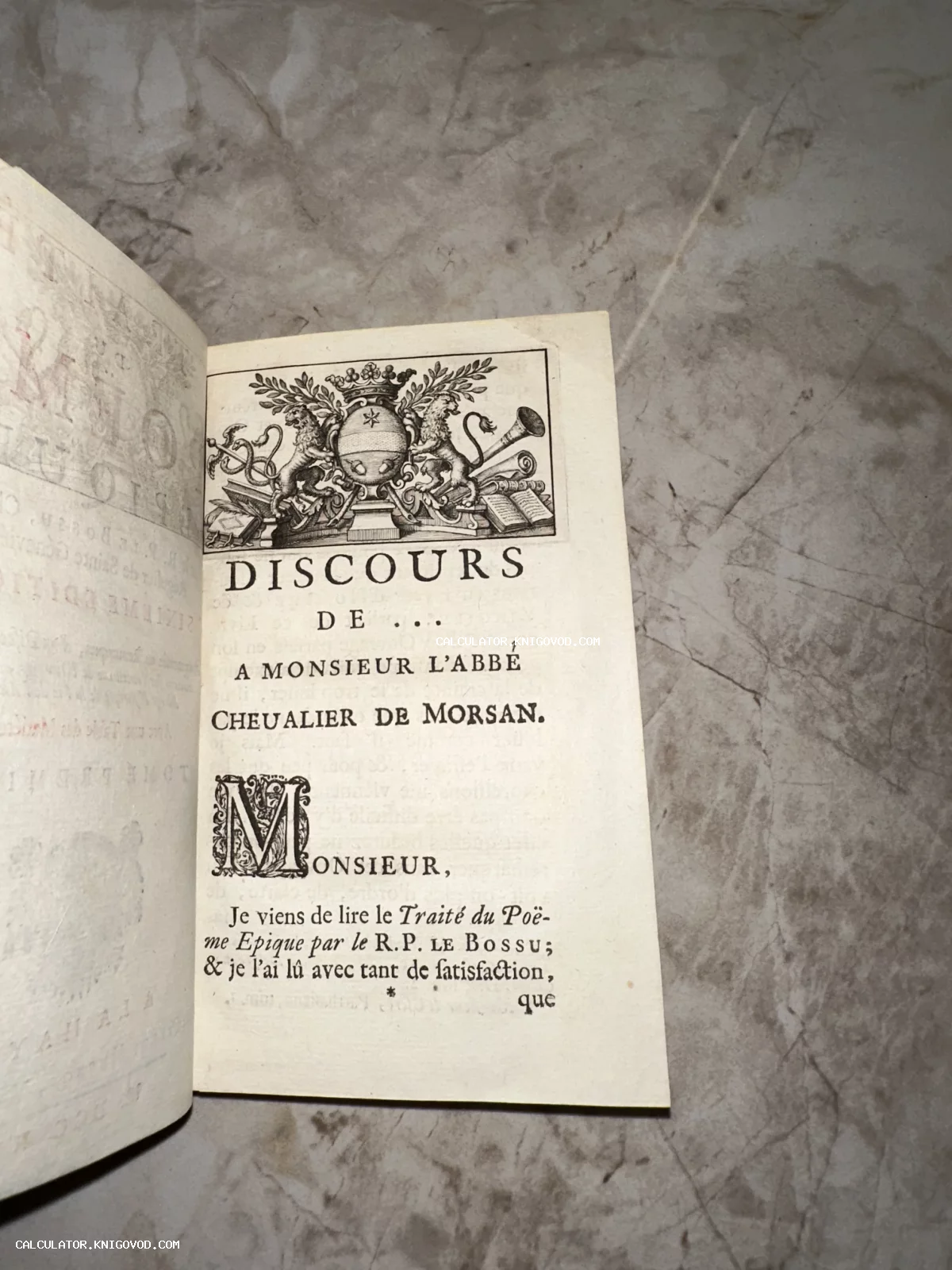 Страница антикварной книги на французском языке с гравированным гербом и декоративной буквицей.