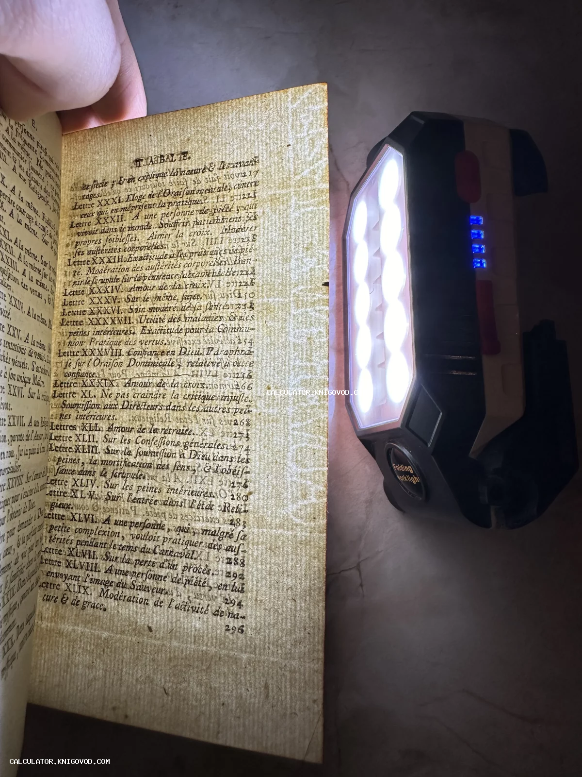 Страница старинной французской книги, подсвеченная мощным фонарем для выявления водяных знаков и структуры бумаги верже.