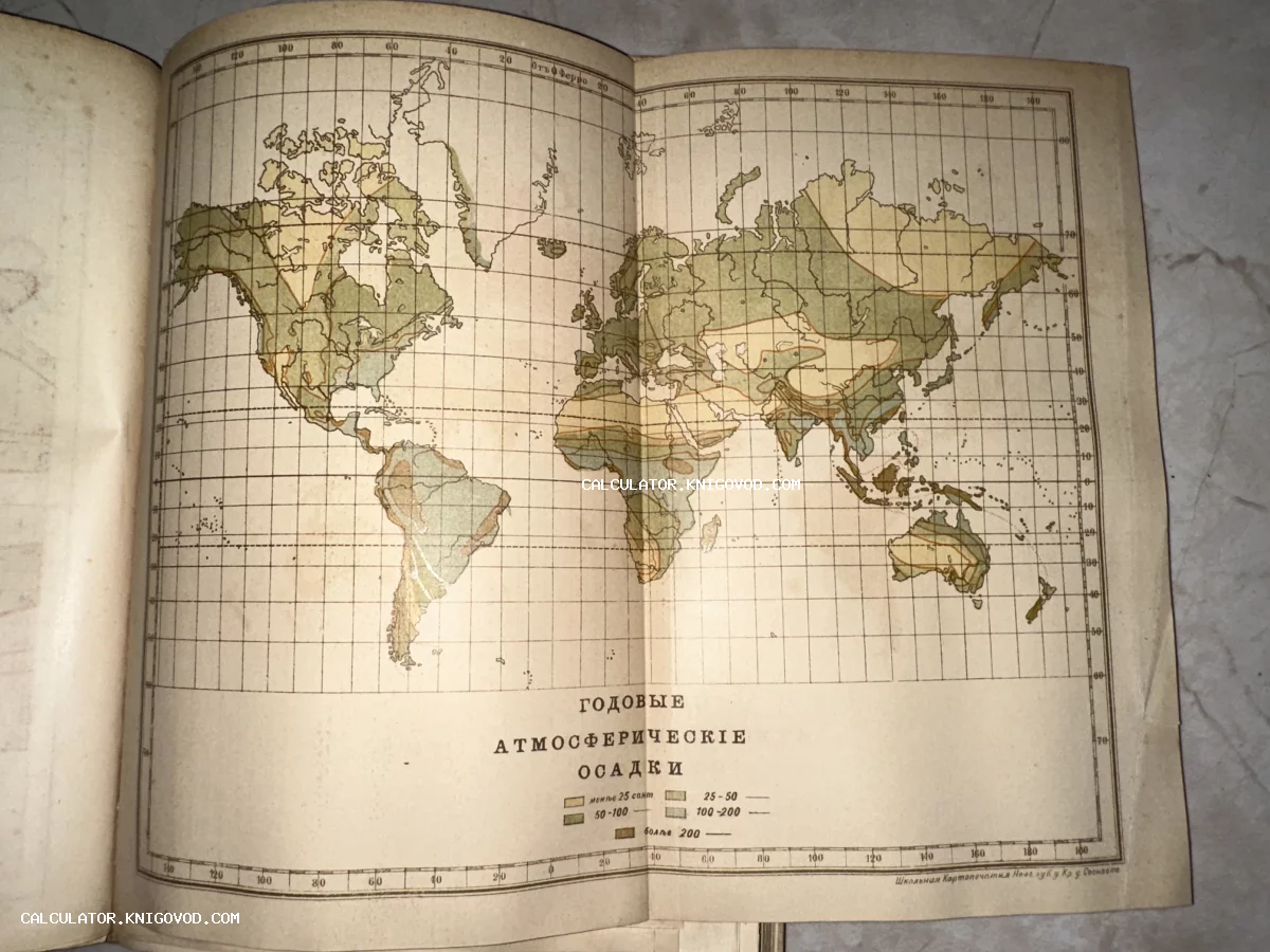 Разворот старинной книги с цветной литографированной картой мира, показывающей уровни осадков.