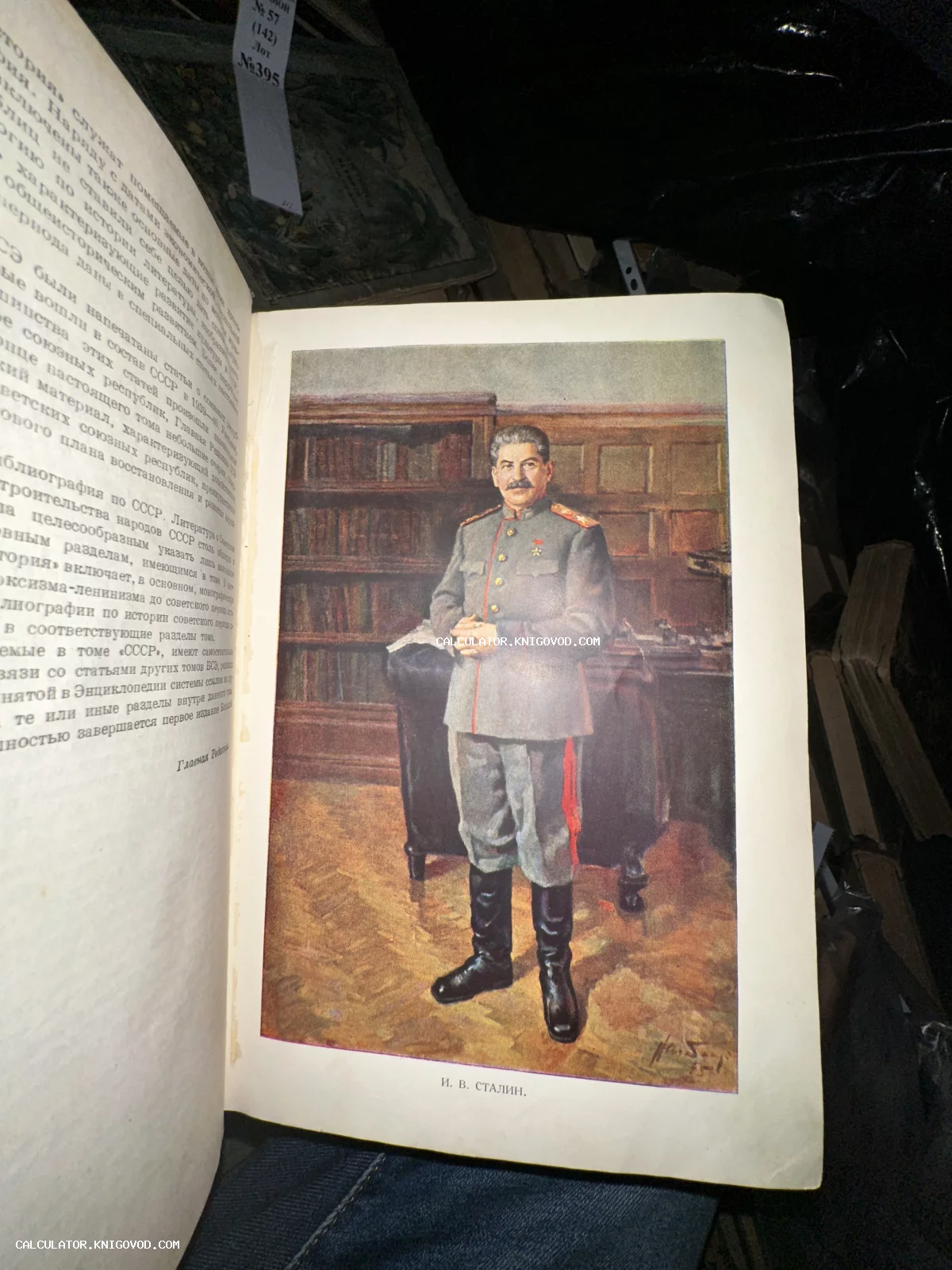 Разворот старой книги с цветной иллюстрацией, изображающей Иосифа Сталина в военной форме в рабочем кабинете.