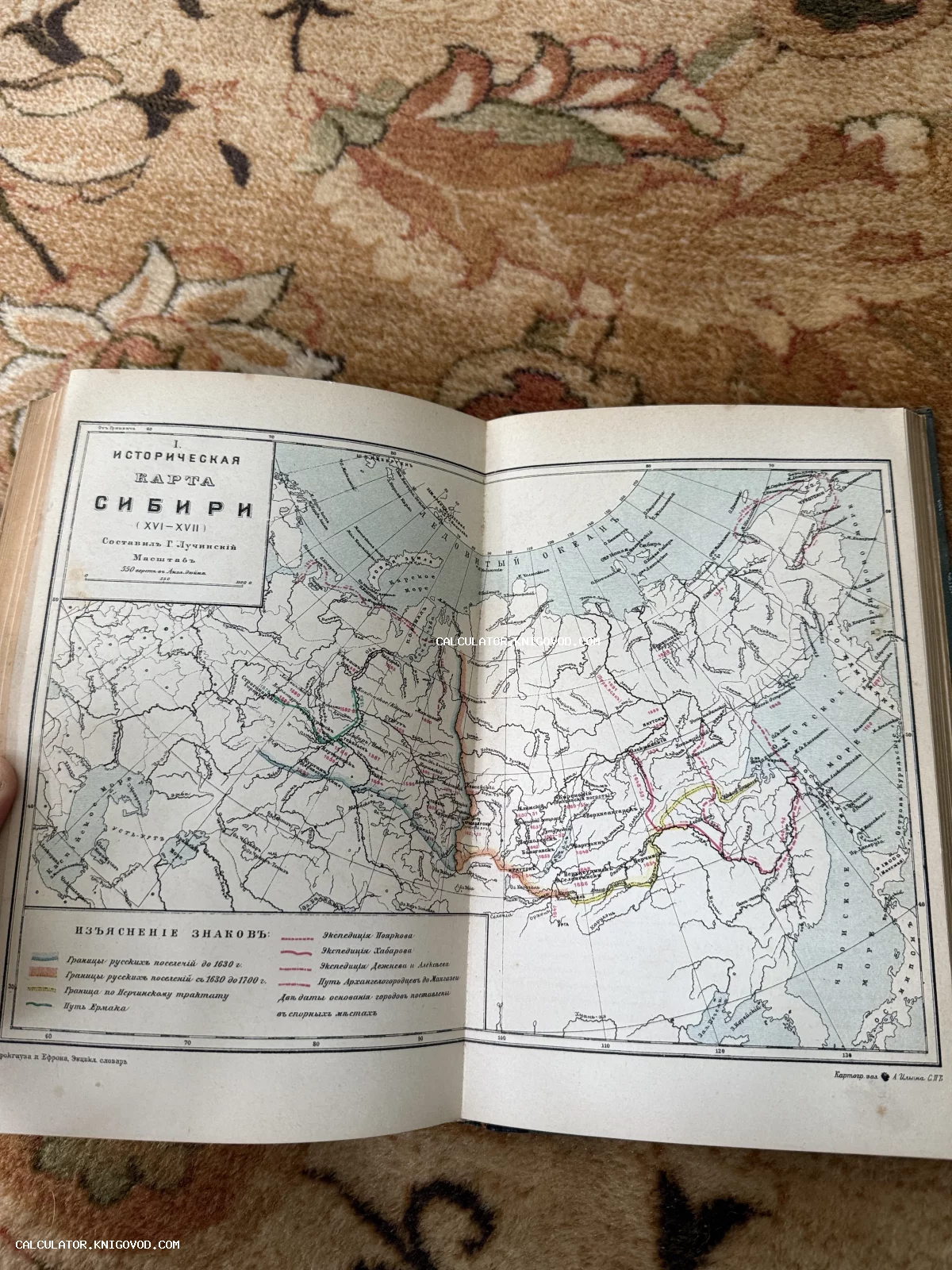 Разворот антикварного издания со старинной картой Сибири, на которой отмечены пути первопроходцев и границы поселений.