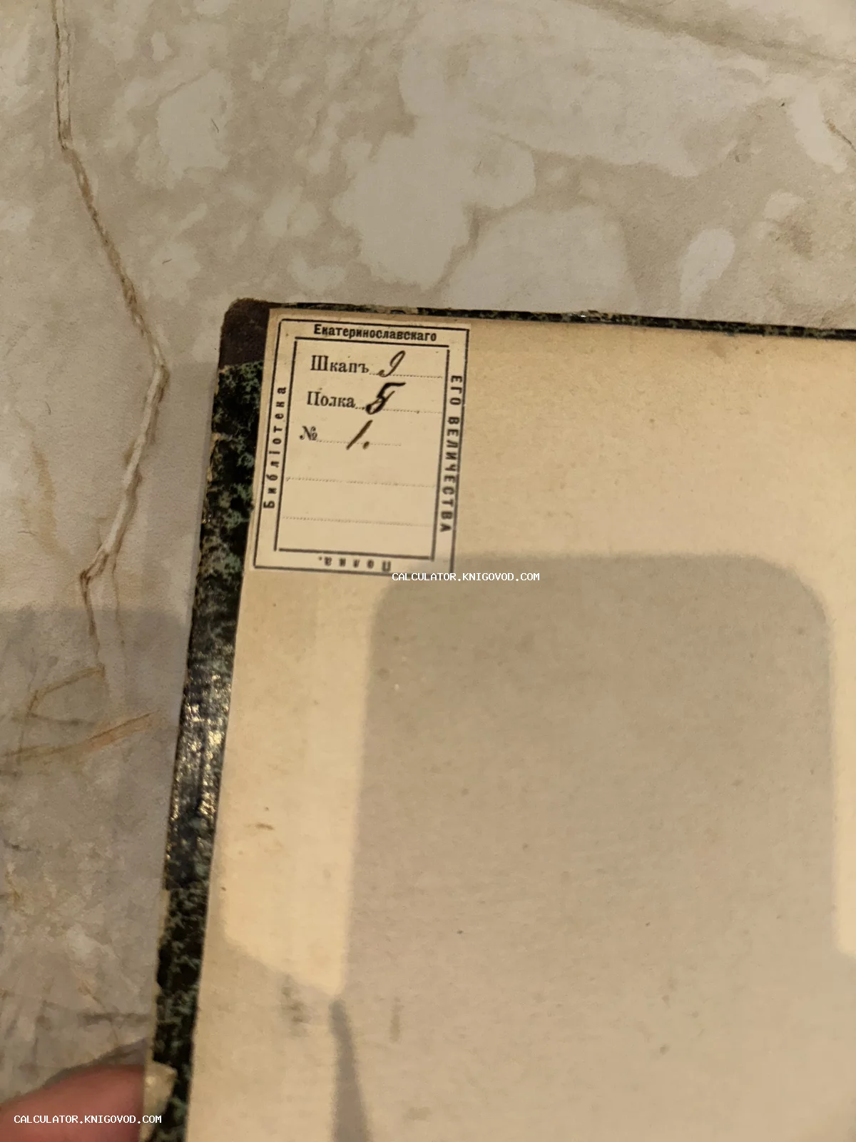 Старинный библиотечный штамп на форзаце антикварной книги с указанием шкафа, полки и инвентарного номера.