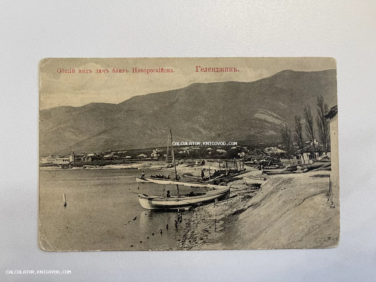 Черно-белая почтовая открытка начала XX века с видом на побережье Геленджика, горы и рыбацкие лодки.