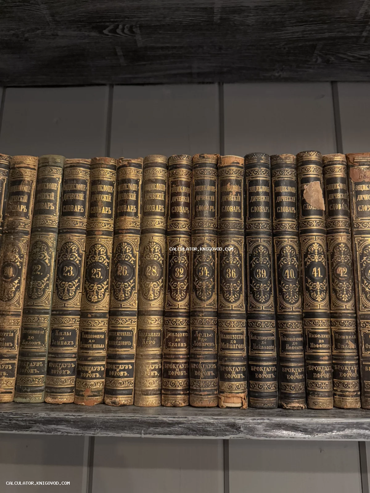 Корешки старинных томов энциклопедии Брокгауза и Ефрона с золотым тиснением на полке.