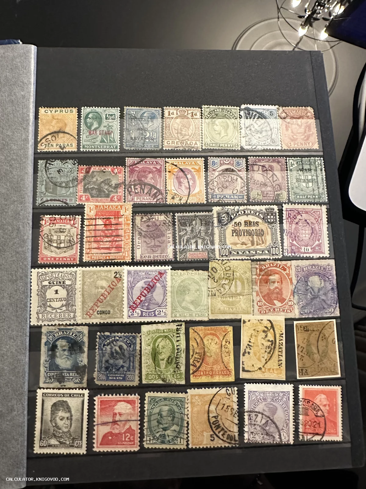 Страница черного филателистического альбома со старинными почтовыми марками разных стран и колоний конца XIX — начала XX века.