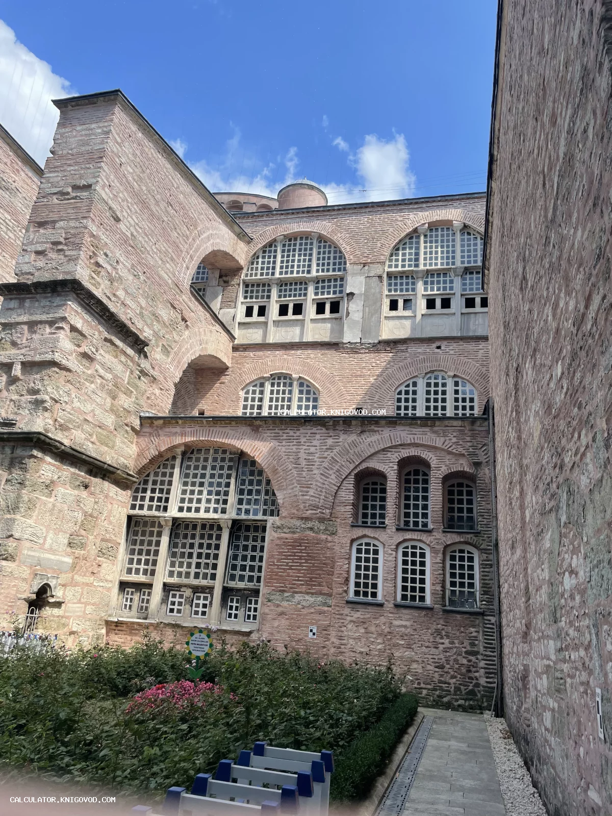 Вид на фасад собора Святой Софии в Стамбуле с характерными арочными окнами и многовековой кирпичной кладкой.