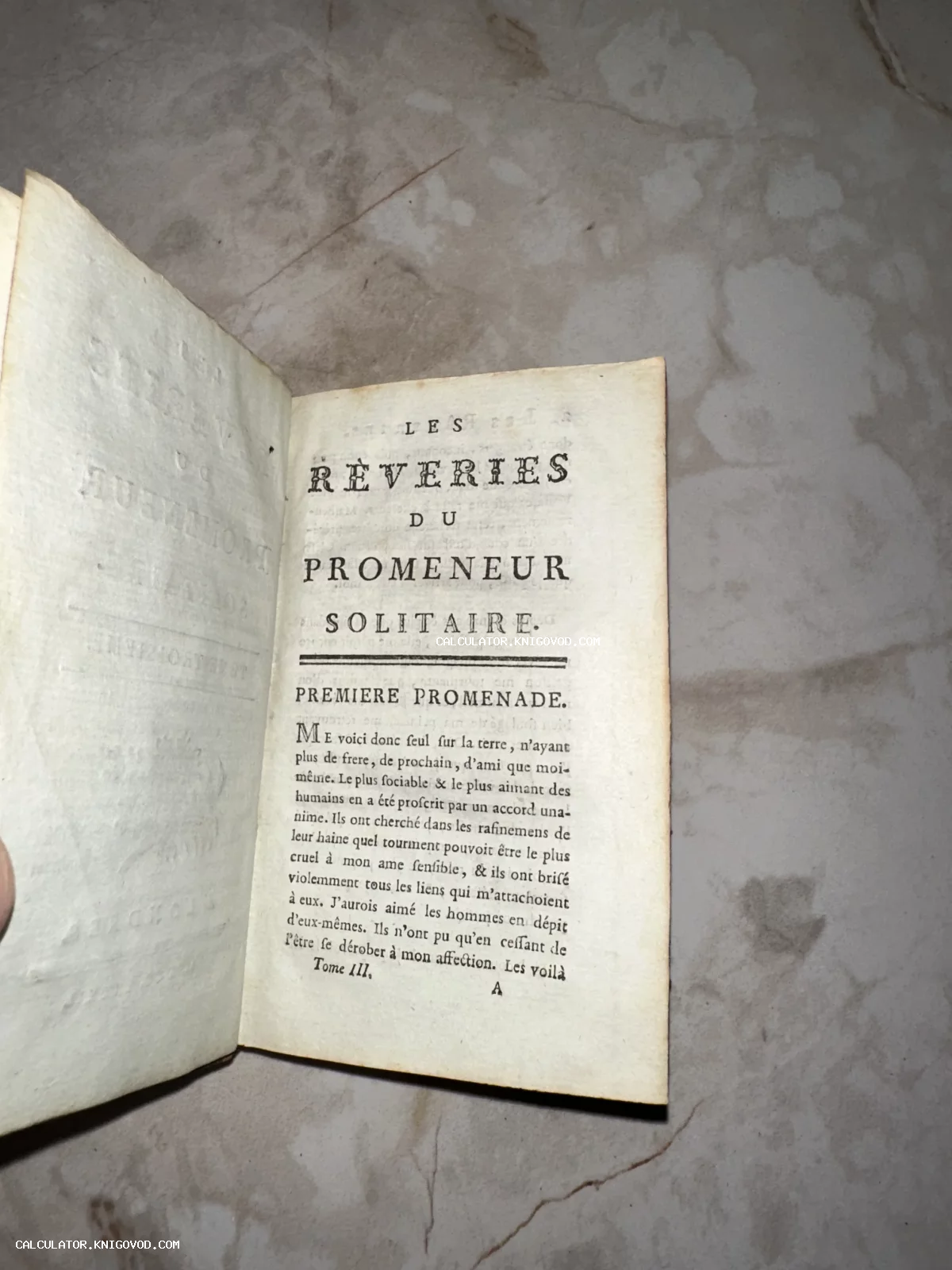 Разворот старинной французской книги с заголовком Les Rêveries du Promeneur Solitaire на пожелтевшей бумаге.