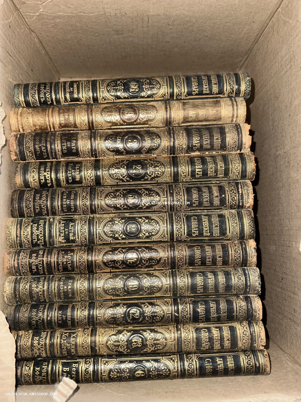 Стопка антикварных томов словаря Брокгауза и Ефрона с золотым тиснением на корешках в коробке.