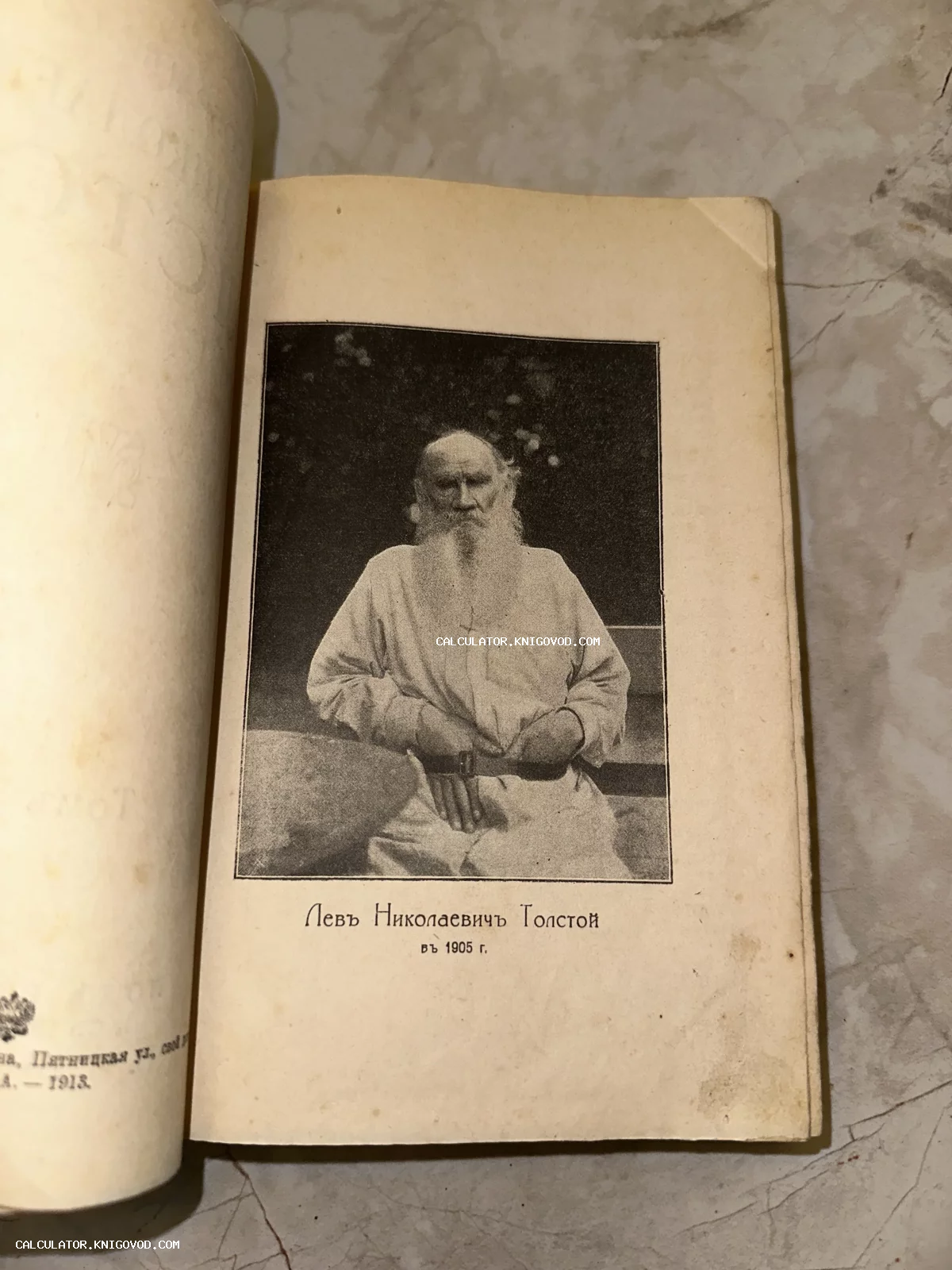 Черно-белая фотография-вклейка с портретом Льва Николаевича Толстого на странице старинной книги.