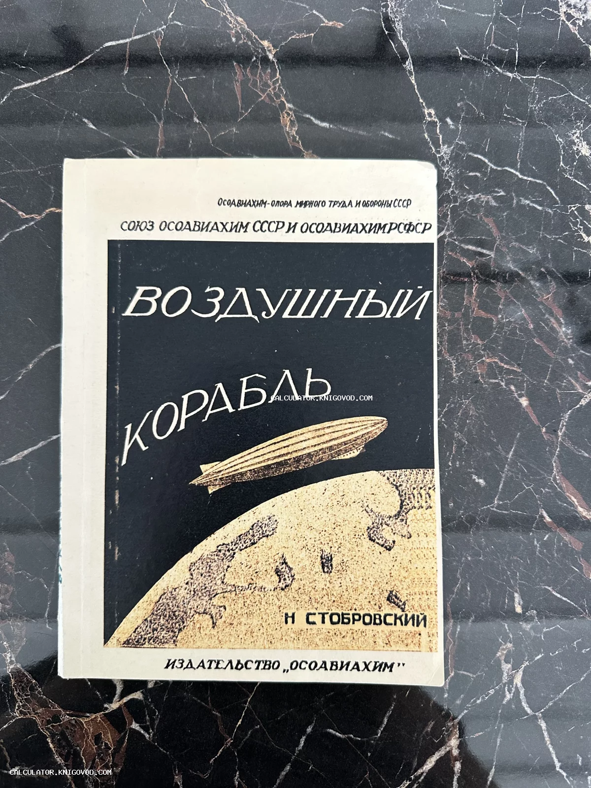 Лицевая сторона советской книги Н. Стобровского «Воздушный корабль» с изображением дирижабля, парящего над земным шаром.