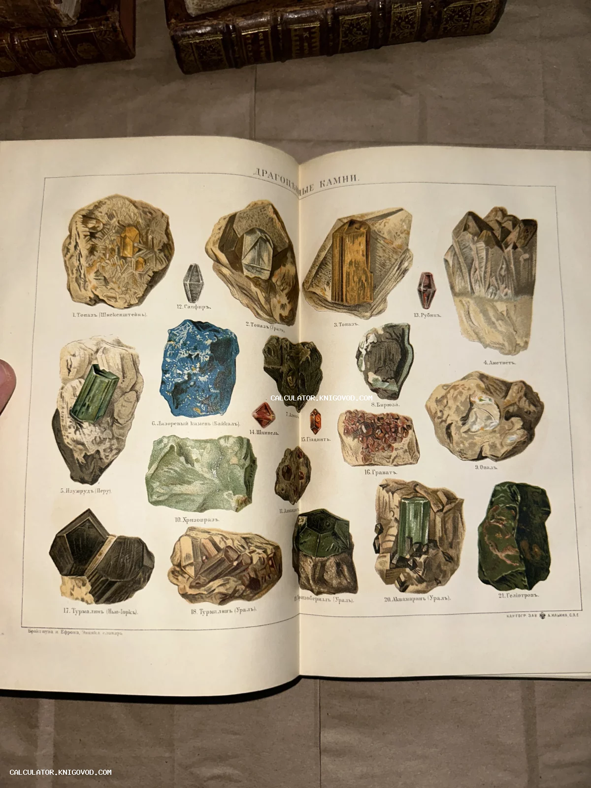 Разворот старинной книги с цветной иллюстрацией различных минералов и драгоценных камней с подписями на русском языке.