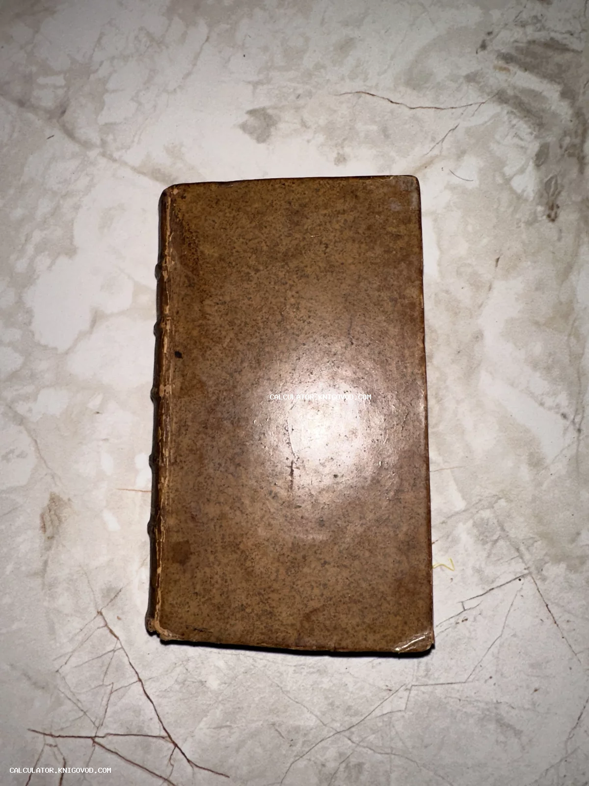 Вид сверху на старинную книгу в потертом коричневом переплете на светлом фоне