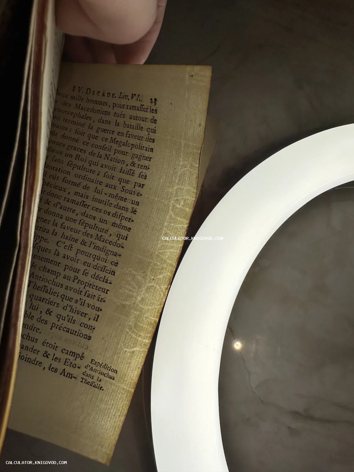 Старинная страница книги на французском языке с заголовком IV DECADE под кольцевым светом.