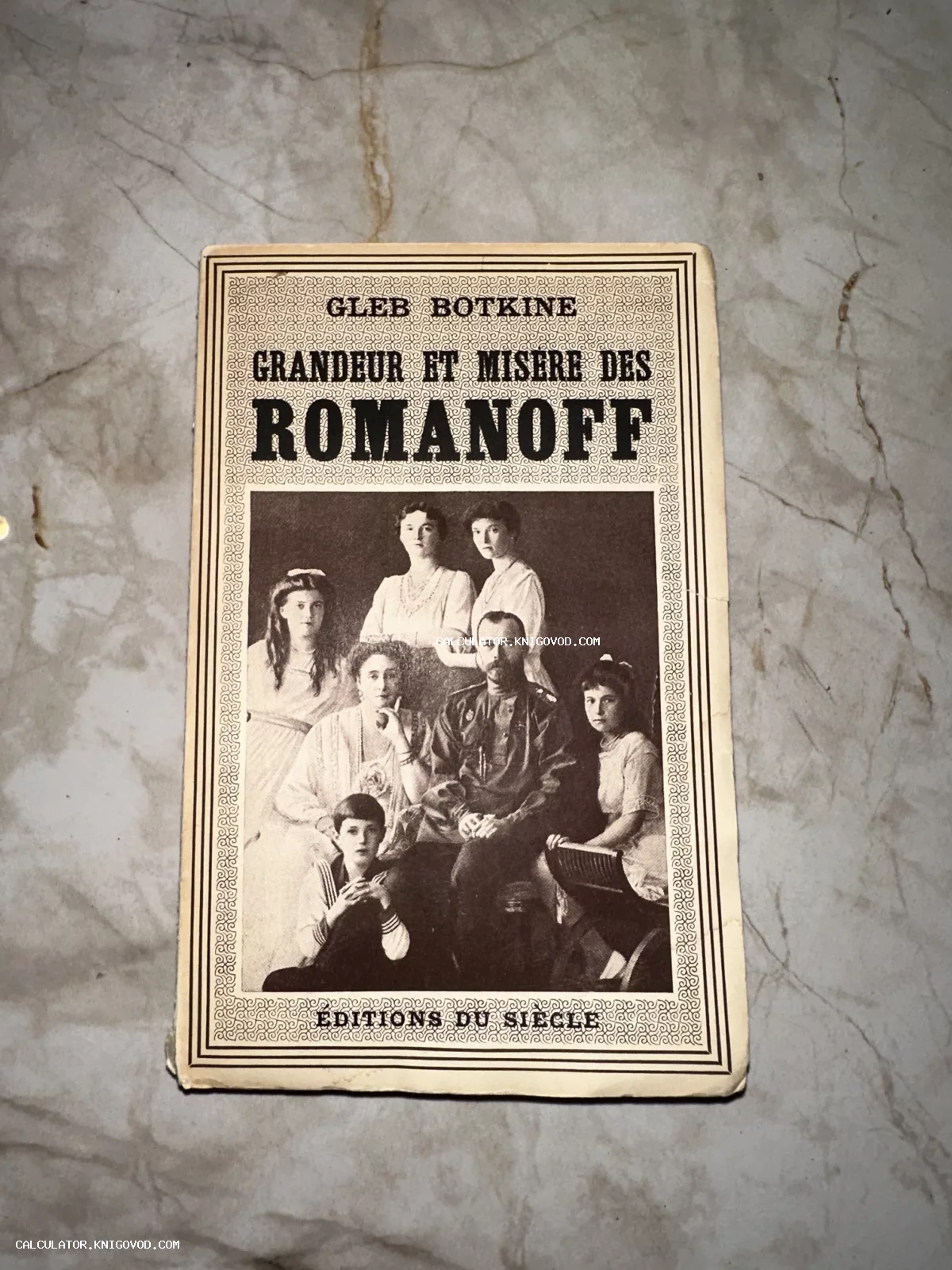 Обложка антикварной книги Глеба Боткина 'Grandeur et Misere des Romanoff' с черно-белой фотографией семьи Николая II.