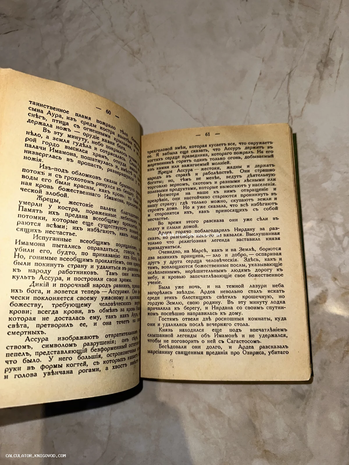 Разворот старой книги с пожелтевшими страницами, напечатанной дореволюционным шрифтом, на мраморном фоне.