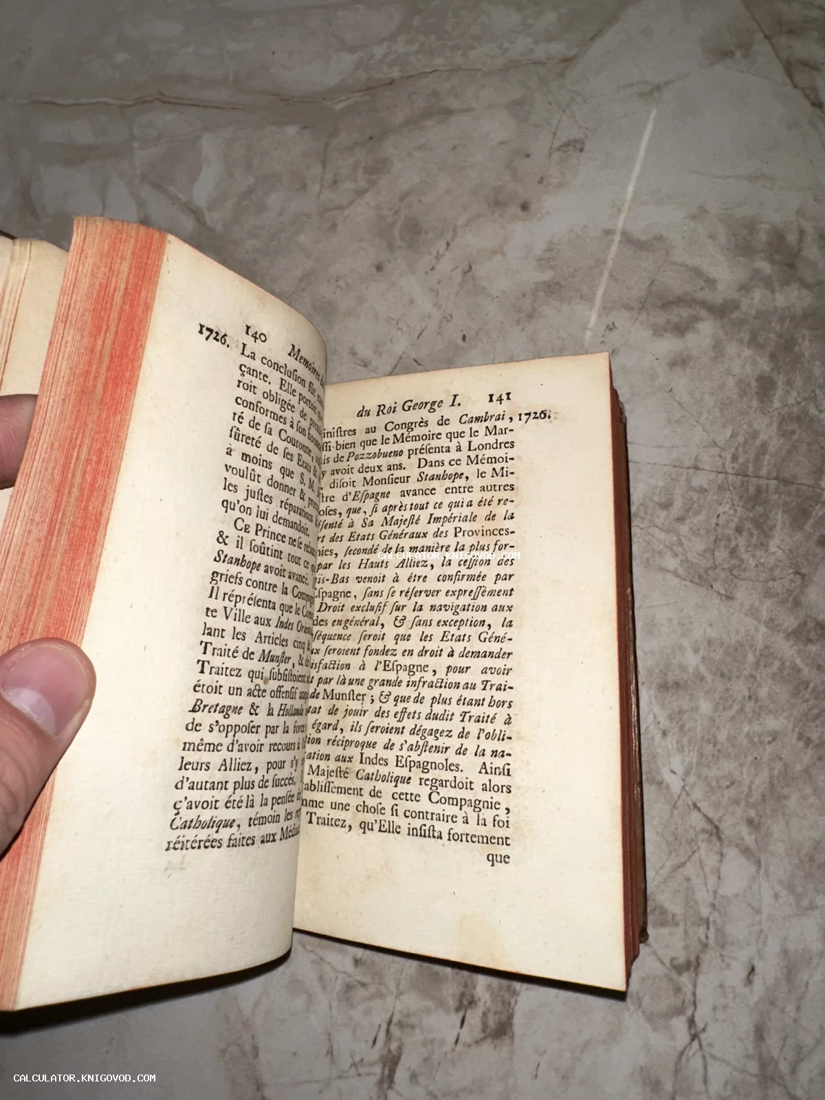 Разворот антикварной книги на французском языке с упоминанием короля Георга I и красным тонированным обрезом.