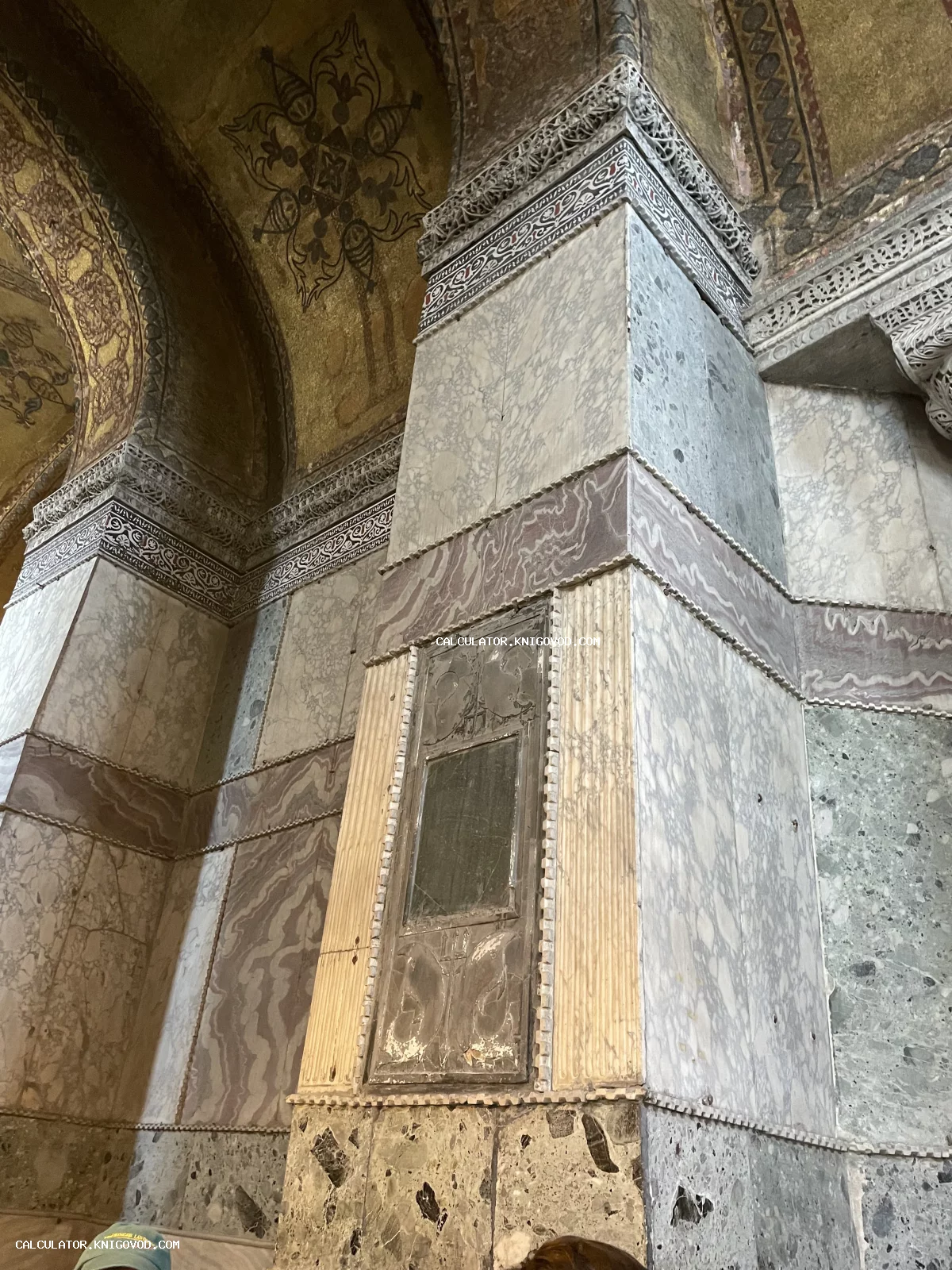 Интерьер древнего храма с массивными колоннами, облицованными цветным мрамором, и золотыми мозаиками на сводах.