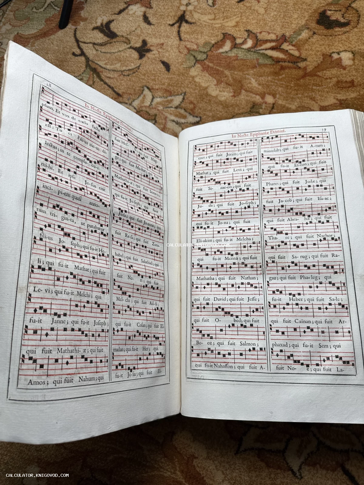 Разворот антикварной книги с церковными песнопениями, латинским текстом и квадратной нотацией на красном стане.