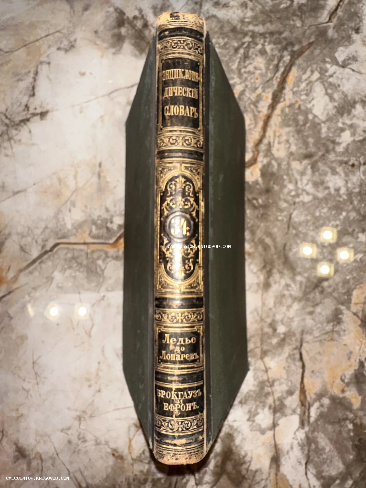 Корешок антикварной книги Энциклопедический словарь Брокгауза и Ефрона с золотым тиснением на мраморном фоне.