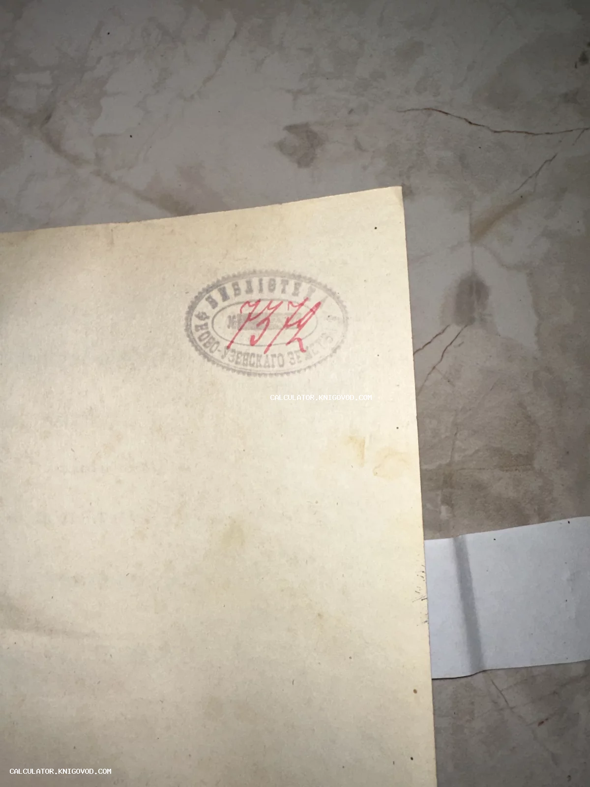 Крупный план страницы старинной книги с овальной печатью Библиотека Ново-Узенскаго земства и рукописным номером 7372 красными чернилами.