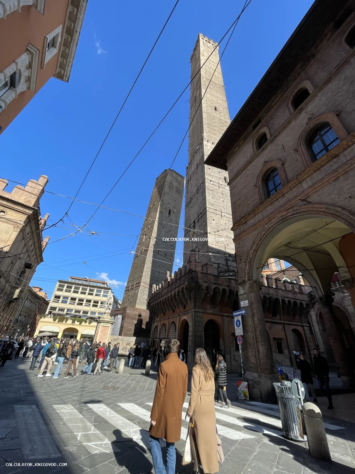 Вид снизу на средневековые башни Азинелли и Гаризенда в Болонье на фоне ярко-синего неба.