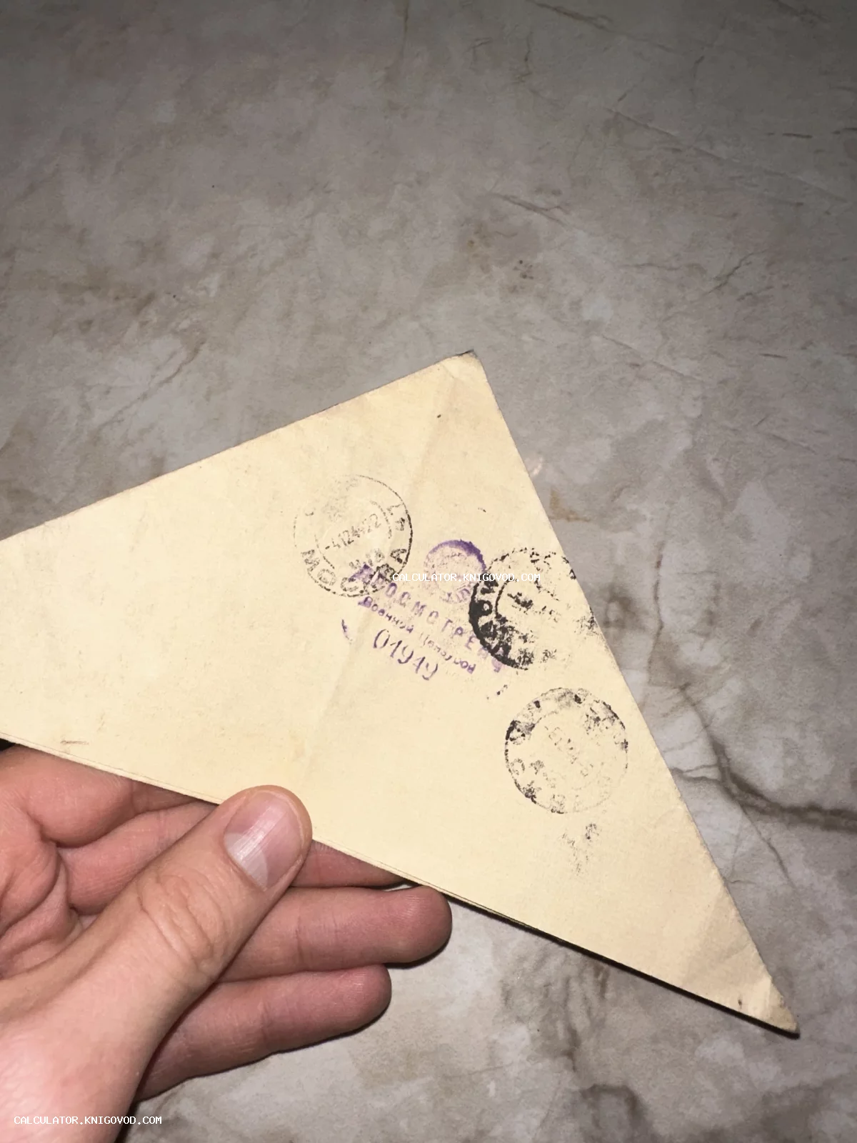 Старинное треугольное письмо с почтовыми штемпелями и фиолетовым штампом военной цензуры на пожелтевшей бумаге.