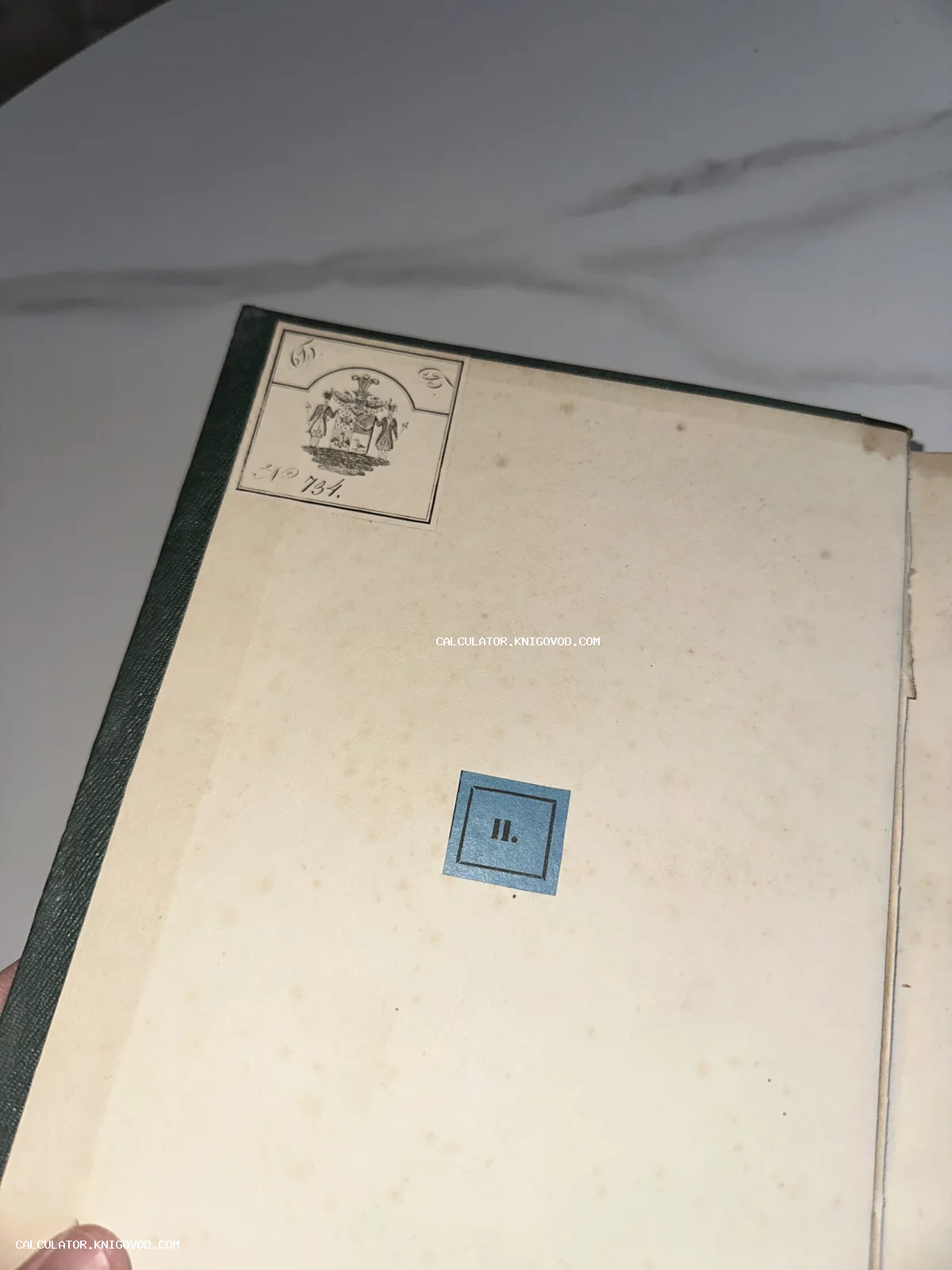 Внутренняя сторона переплета старинной книги с наклеенным экслибрисом, изображающим герб, и синей квадратной меткой с римской цифрой II.