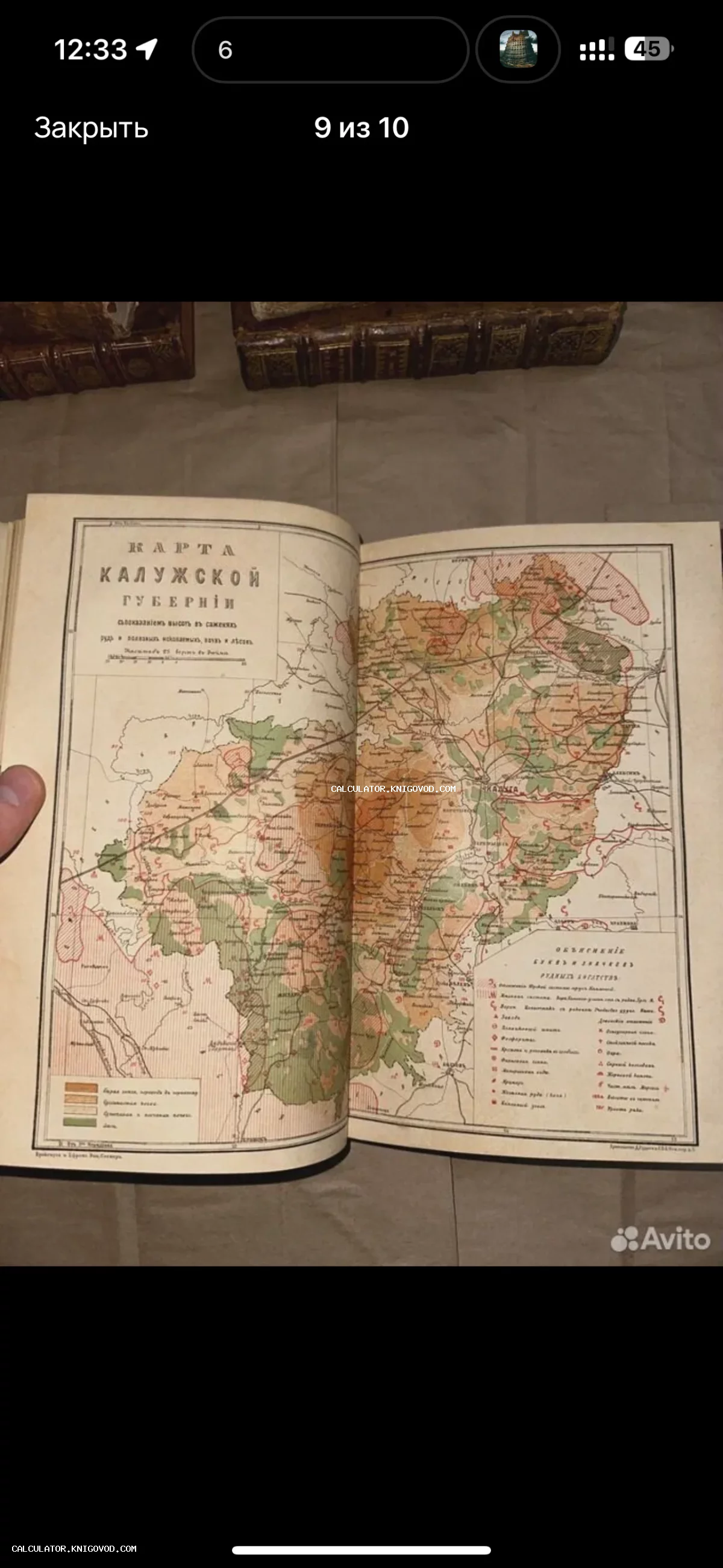 Разворот старинной книги с подробной цветной картой Калужской губернии XIX века, включающей легенду и топографические обозначения.