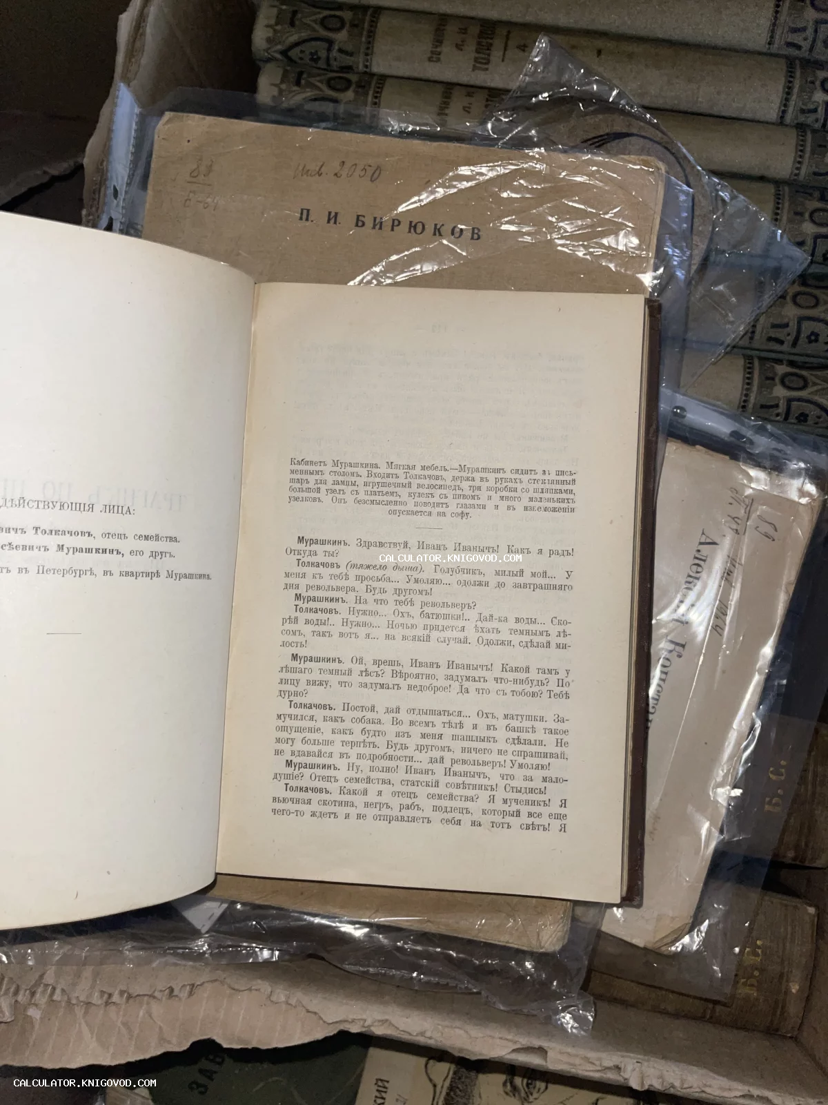 Разворот старинной книги с текстом на дореволюционном русском языке, лежащий поверх других антикварных томов.