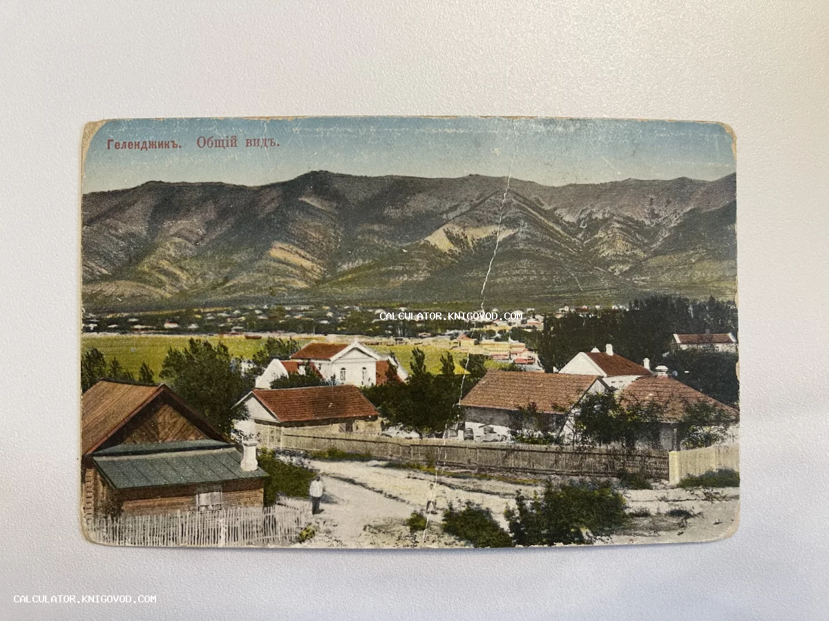 Дореволюционная раскрашенная открытка с видом на Геленджик, жилые дома с черепичными крышами и горы на заднем плане.