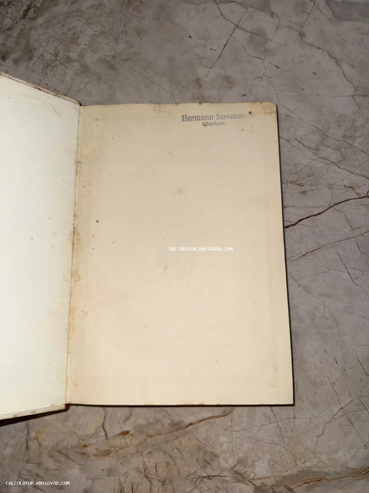 Разворот старинной книги с пожелтевшими страницами и синим чернильным штампом Hermann Strecker Charkow в верхнем углу.