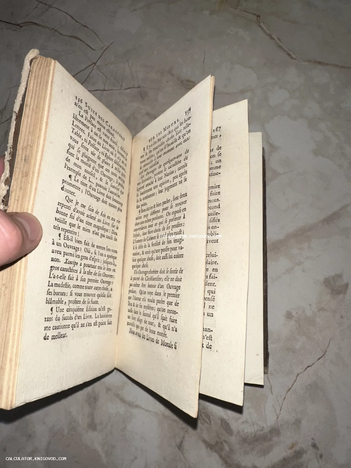 Раскрытая старинная книга на французском языке с пожелтевшими страницами и классическим шрифтом того времени.