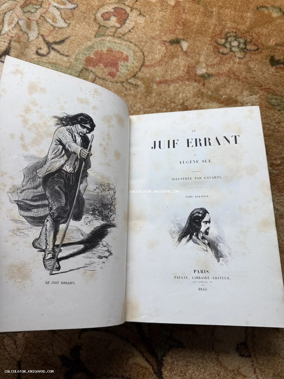 Разворот старинной книги 'Le Juif Errant' с фронтисписом и титульным листом на фоне ковра.